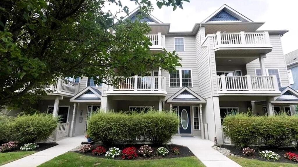 a large apartment building with bushes and flowers at Beautiful 4 Bedroom Condo With Pool! in Cape May