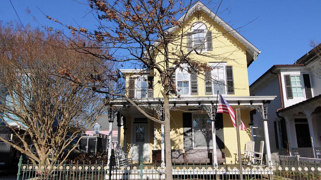 a yellow house with a fence in front of it at The Daisy Cottage- Whole House Rental in Cape May