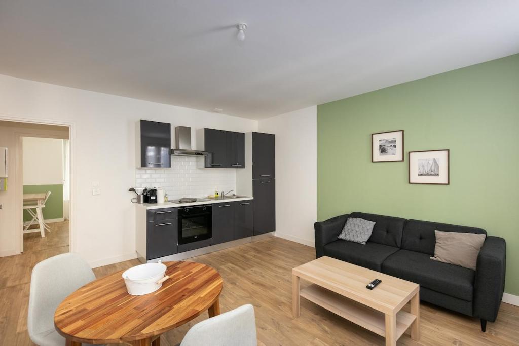 un salon avec un canapé et une table dans l'établissement T2 Kouign Amann, à Brest