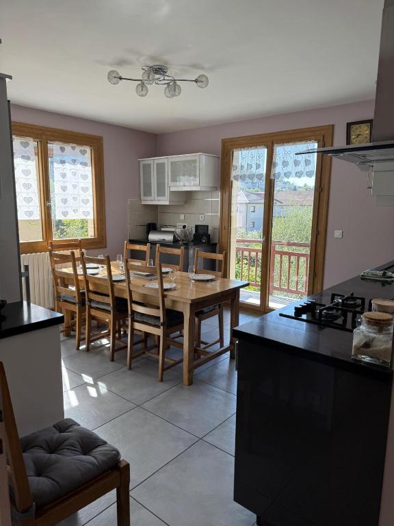 une cuisine et une salle à manger avec une table et des chaises dans l'établissement Le Sonise - Spacious family apartment with balcony garden and parking spac, à Aix-les-Bains