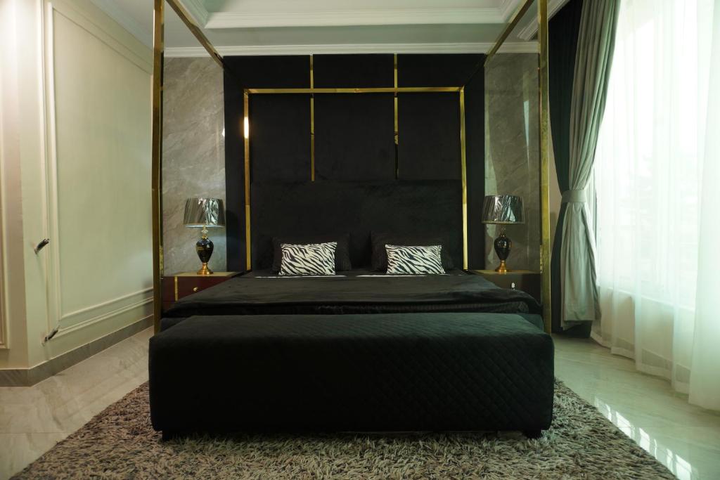 a bedroom with a bed with a black headboard and a rug at Bhurban Homes in Murree