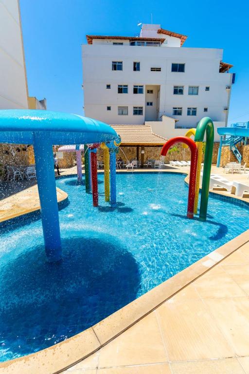 a pool with a water slide in a building at Hotel Meaípe in Guarapari