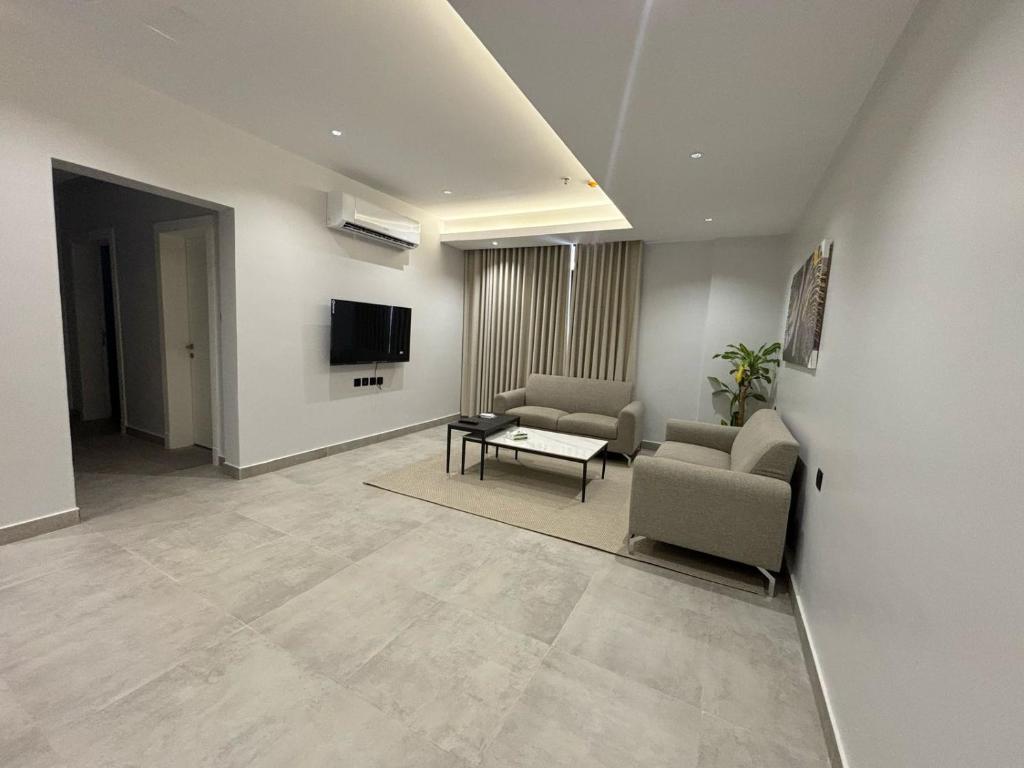 Una sala de estar con un sofá y un televisor en اجنحة راف, en Medina