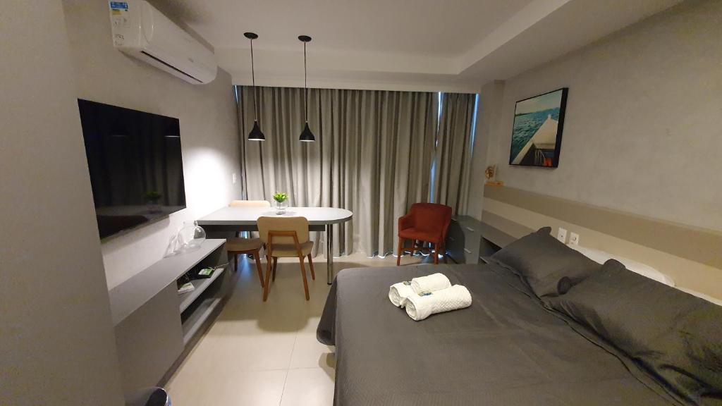 ein Hotelzimmer mit einem Bett und einem Tisch mit Stühlen in der Unterkunft Rooftop 470 #Flat 1005 - Boa Viagem in Recife