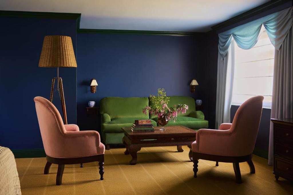 a living room with a green couch and two chairs at Portrush Adelphi in Portrush
