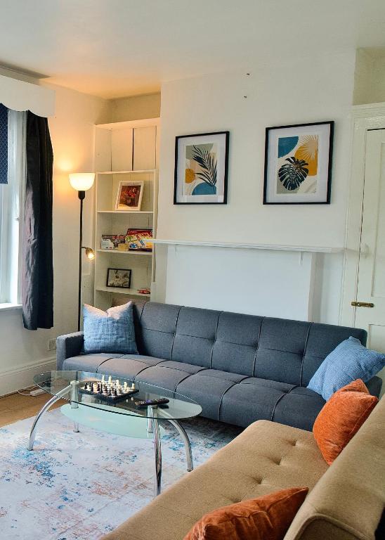 Hotel Modern 2 Bed Apartment, 8min to Stratford Station, Sleeps 6, a living room with a blue couch and a table at Modern 2 Bed Apartment, 8min to Stratford Station, Sleeps 6 in London