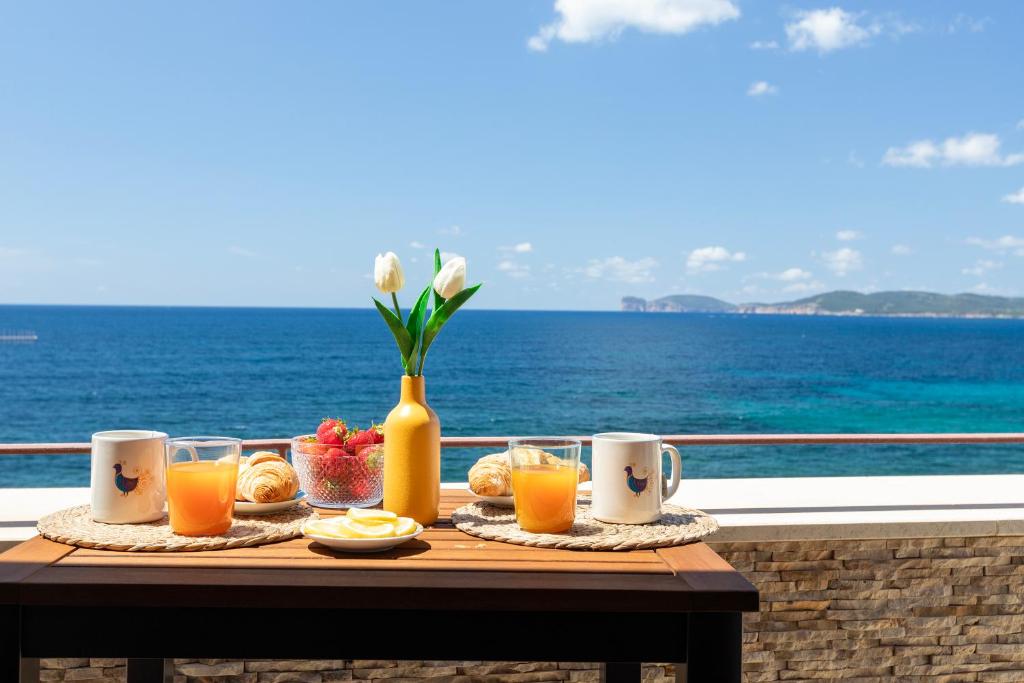 a table with a tray of food and orange juice at ForRest Seaside Loft View 121 in Alghero