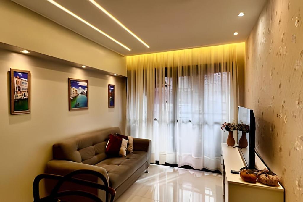 Una sala de estar con un sofá y una ventana. en Apto 2 quartos com garagem, en Belém