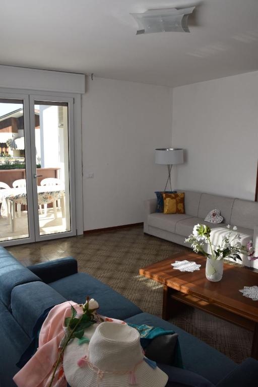 a living room with a blue couch and a table at Appartamento Confine in Concordia Sagittaria