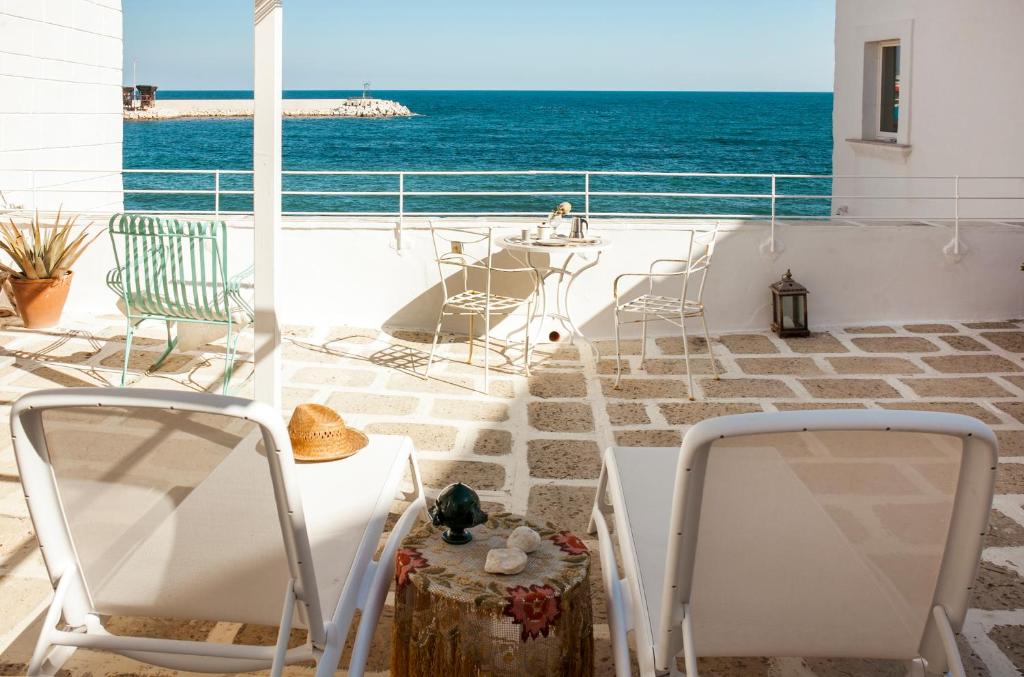 due sedie e un tavolo su un balcone con vista sull'oceano di Casa Solomare by Travel with Gianni a Monopoli