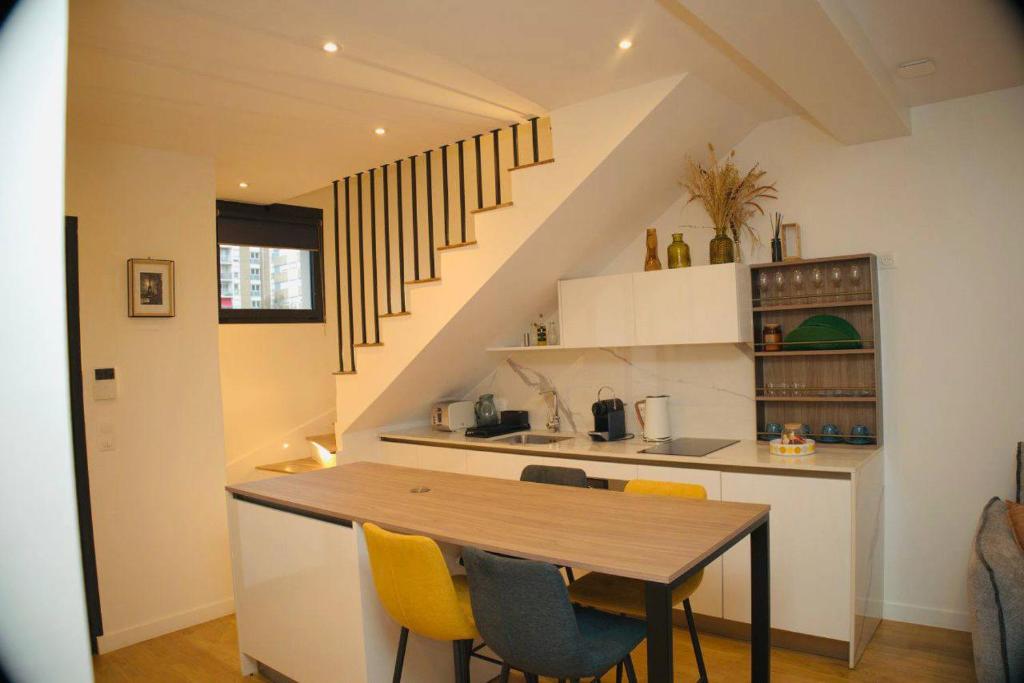 Una cocina con una mesa de madera y sillas amarillas. en Appartement 3, en Les Lilas