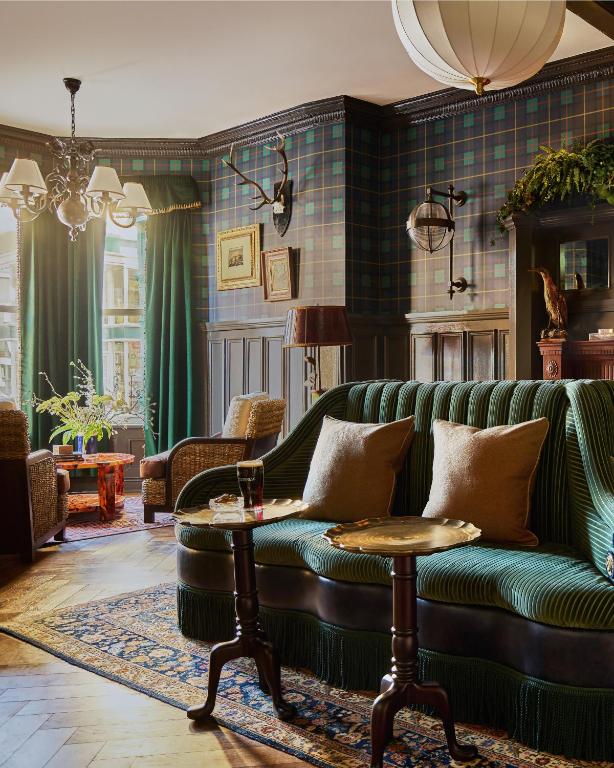 a living room with a green couch and a table at Portrush Adelphi in Portrush