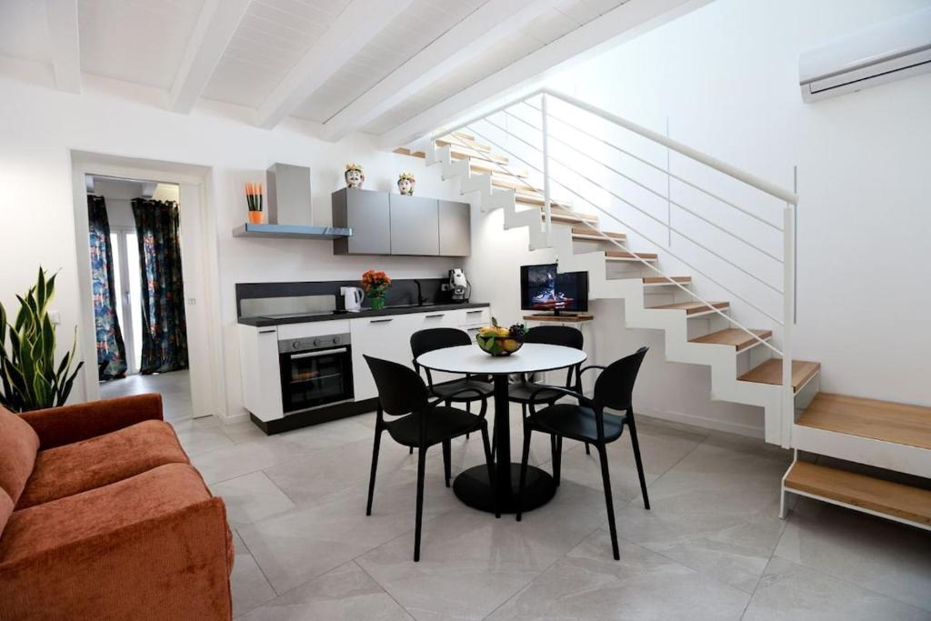 a living room with a table and a staircase at Ivi's House in Palermo