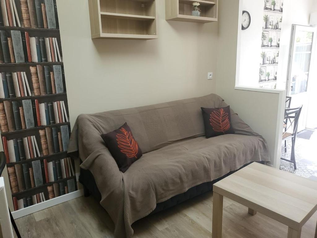 un canapé marron dans un salon avec des livres dans l'établissement Chaillot 1, à Saintes