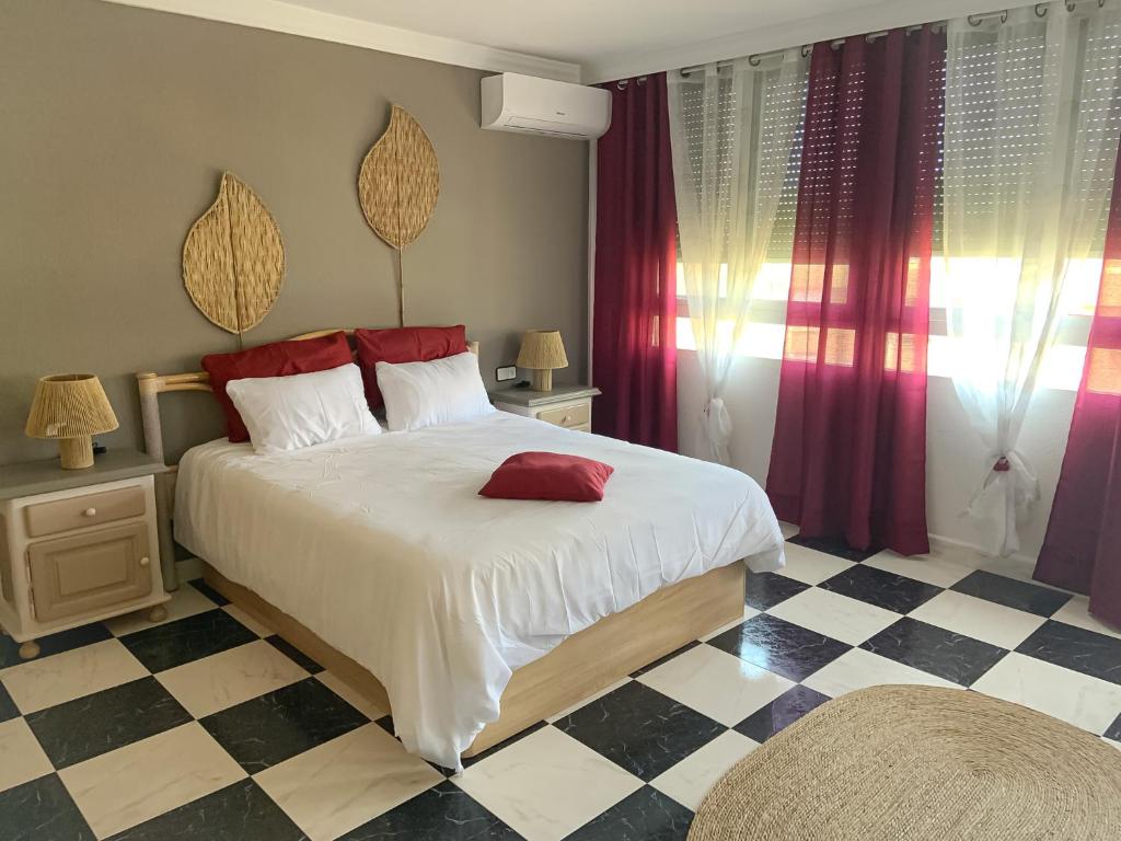een slaapkamer met een groot wit bed met rode kussens bij ATICO AMBERES SEAVIEW PENTHOUSE - Torrox Costa in Castillo Bajo