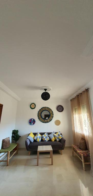 a living room with a couch and a table at Duplex La roseraie à 2min de la plage 2 piscines in Sidi Bouzid
