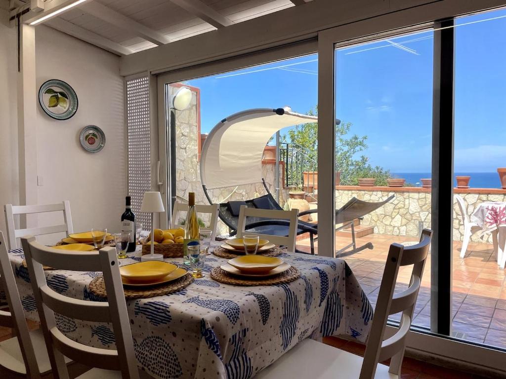a dining room with a table and a view of the ocean at Villa Aloe di Calanica Cefalù in Cefalù