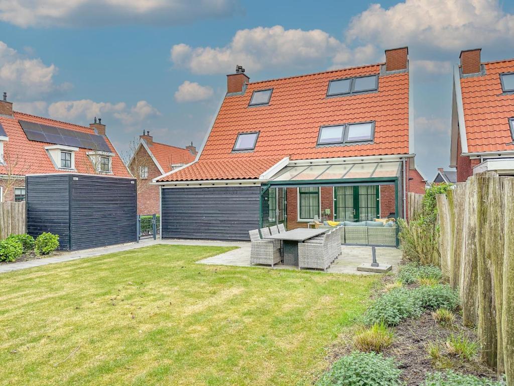 una casa con una valla y un patio en Villa superieur 64, en Colijnsplaat