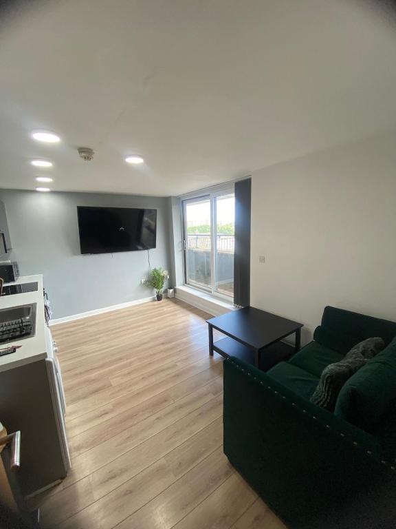 a living room with a couch and a flat screen tv at Modern 1-Bed Flat with Balcony in Bradford