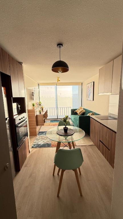 圣地亚哥Centenario 1151- 806A的客厅里有一张桌子和一个厨房