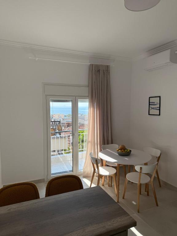 a dining room with a table and chairs and a window at Kapnos - Classy and spacious place with a sea view in Kavála