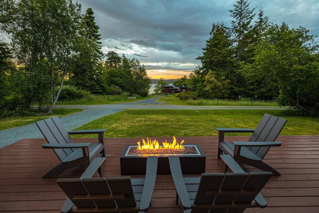 a patio with two chairs and a fire pit at Perch - Greenbank Cottage in Greenbank