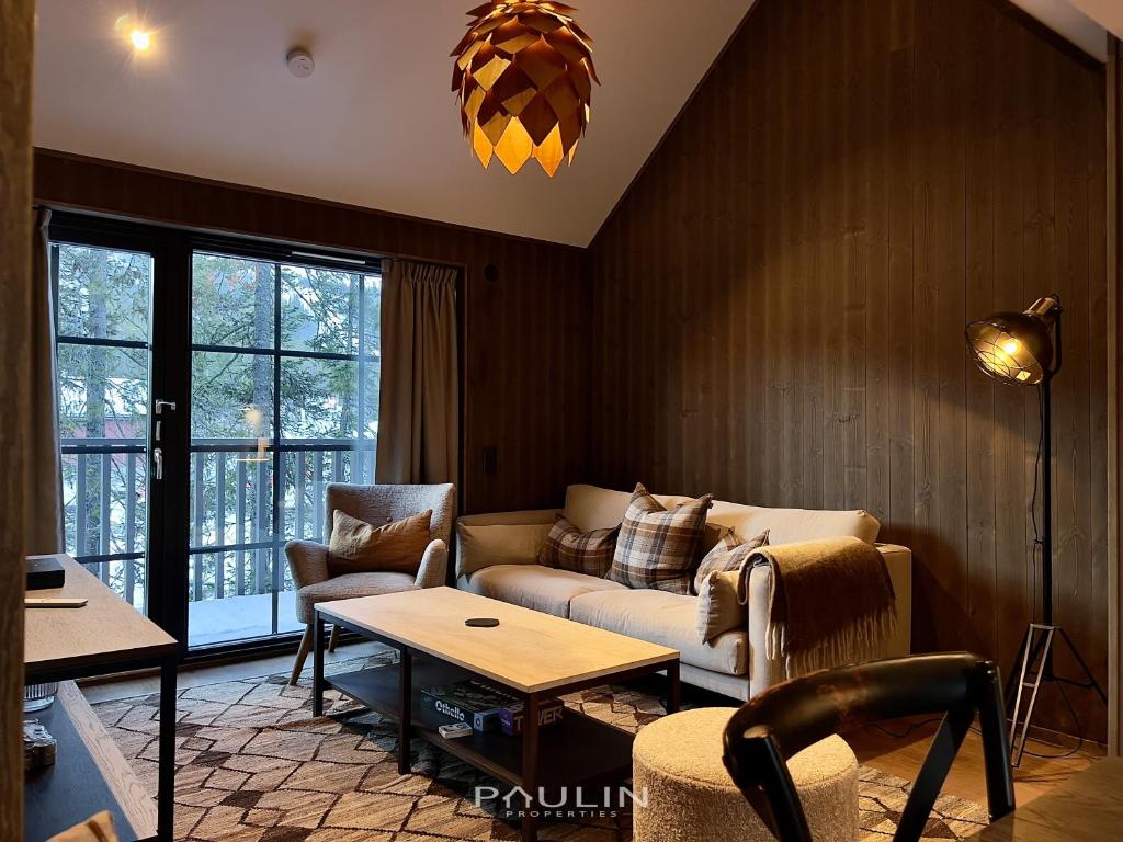 a living room with a couch and a table at Lindvallen Ski Resort Pool and Padel - Sauna - 6 Guests in Sälen