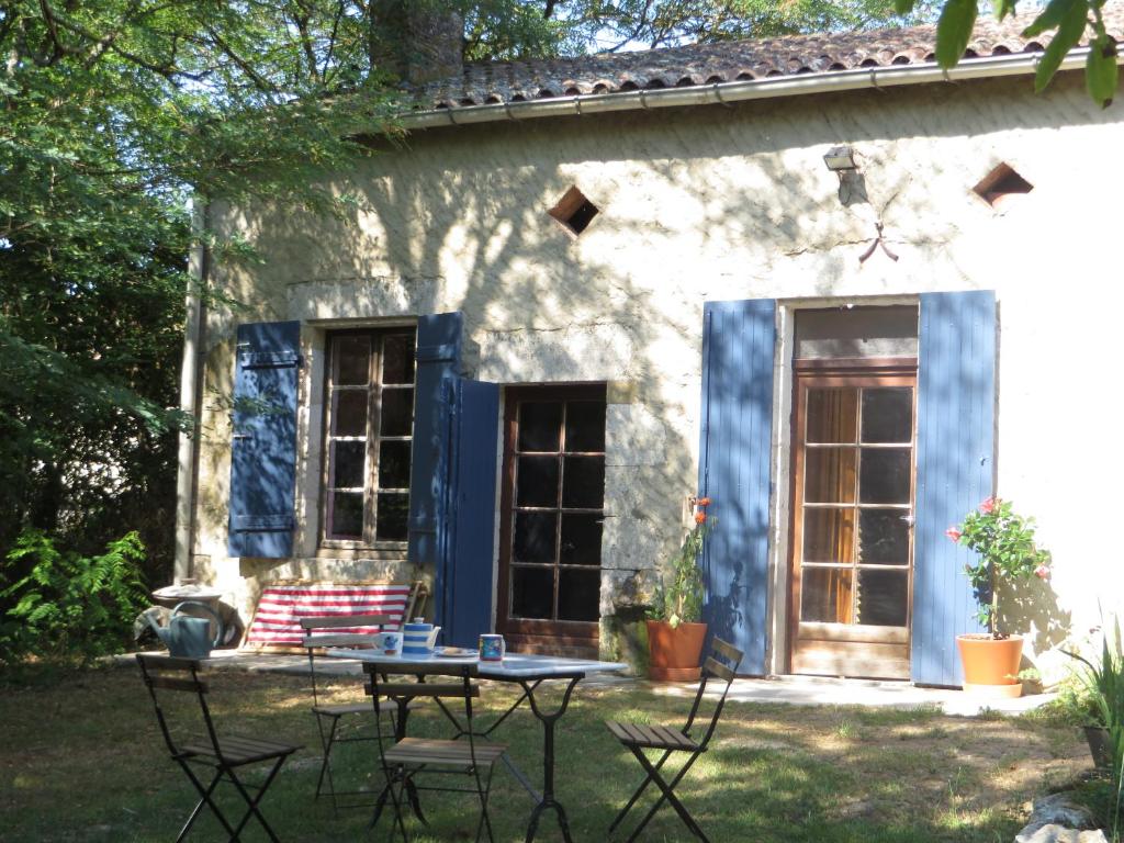 une maison avec une table et des chaises dans la cour dans l'établissement Iris Meadow Cottage, à Gardonne