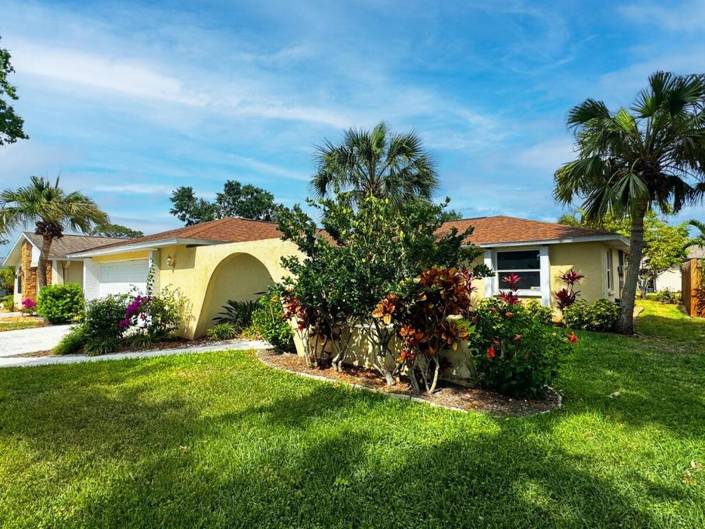 una casa con un patio verde con palmeras en House with private Pool, close to beaches, Golf, en Venice