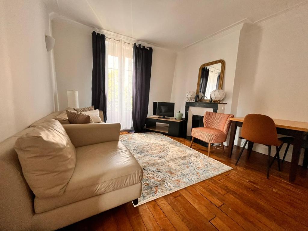 un salon avec un canapé, une table et un miroir dans l'établissement Rêve d'été à Paris, à Paris