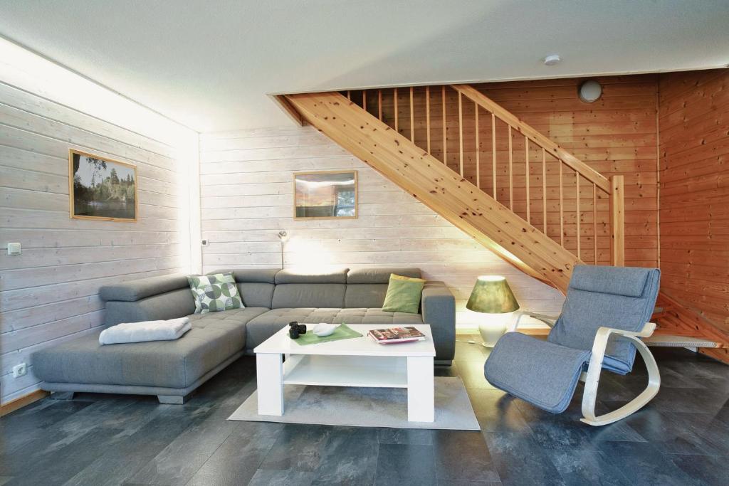a living room with a couch and a table at Modernes Ferienhaus mit Kamin & Garten in ruhiger Lage in Hasselfelde