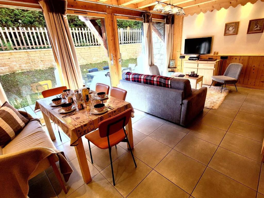 un salon avec une table et un canapé dans l'établissement Duplex lumineux avec terrasse et balcon, proche centre et pistes, parking, WiFi - FR-1-598-71, aux Gets