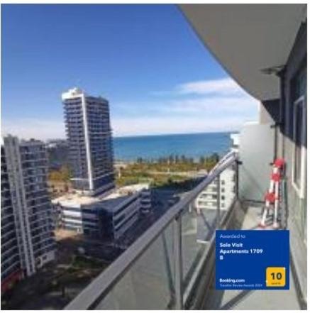 a balcony with a view of the ocean and buildings at Solo Visit Apartments 1709 B in Batumi