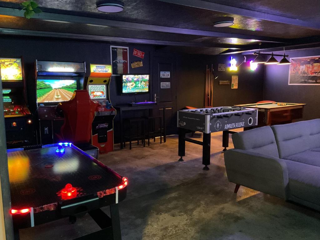 a living room with arcade games and a ping pong table at Domaine Le Rocher d Argent avec Piscine Extérieur ,Jacuzzi Intérieur et Salle de jeux in Berre-les Alpes