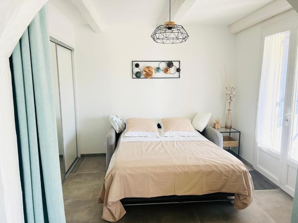 une chambre avec un lit dans une pièce blanche dans l'établissement Villa - Vue Mer et Tranquilité, à Carqueiranne