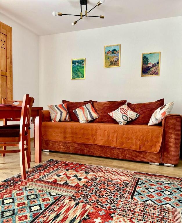 a brown couch in a living room with a table at Clabucet View Apartment in Predeal