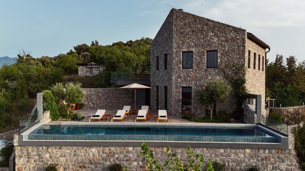 una casa de piedra con piscina frente a ella en Villa Diamonte, en Ðuraševići