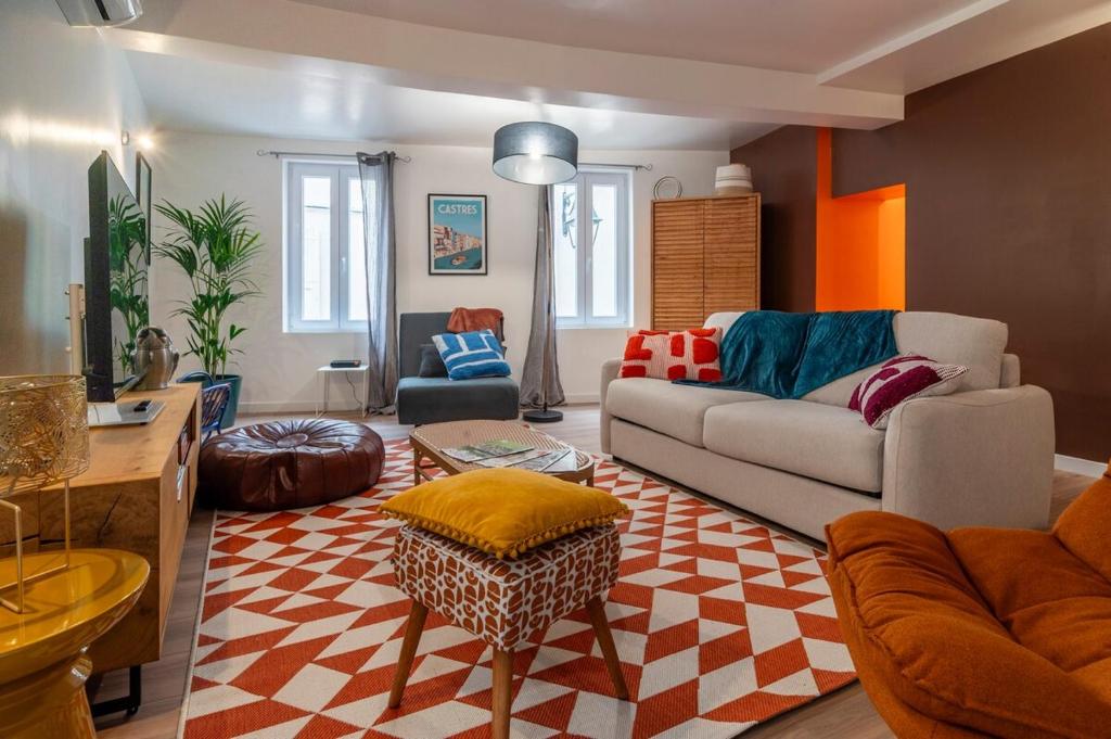 a living room with a couch and a table at Le Baron terrasse et parking cœur de Castres in Castres