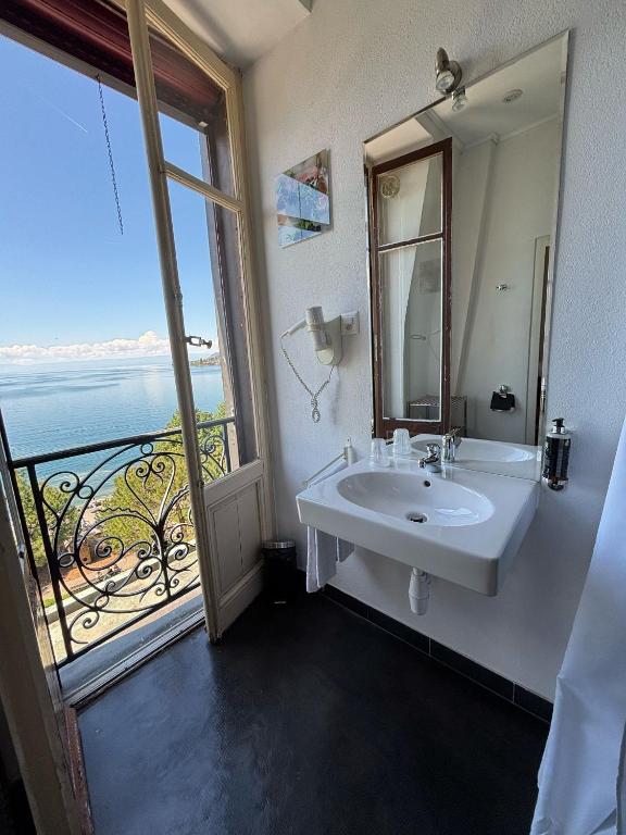um banheiro com pia e uma janela grande em Hotel Parc & Lac em Montreux