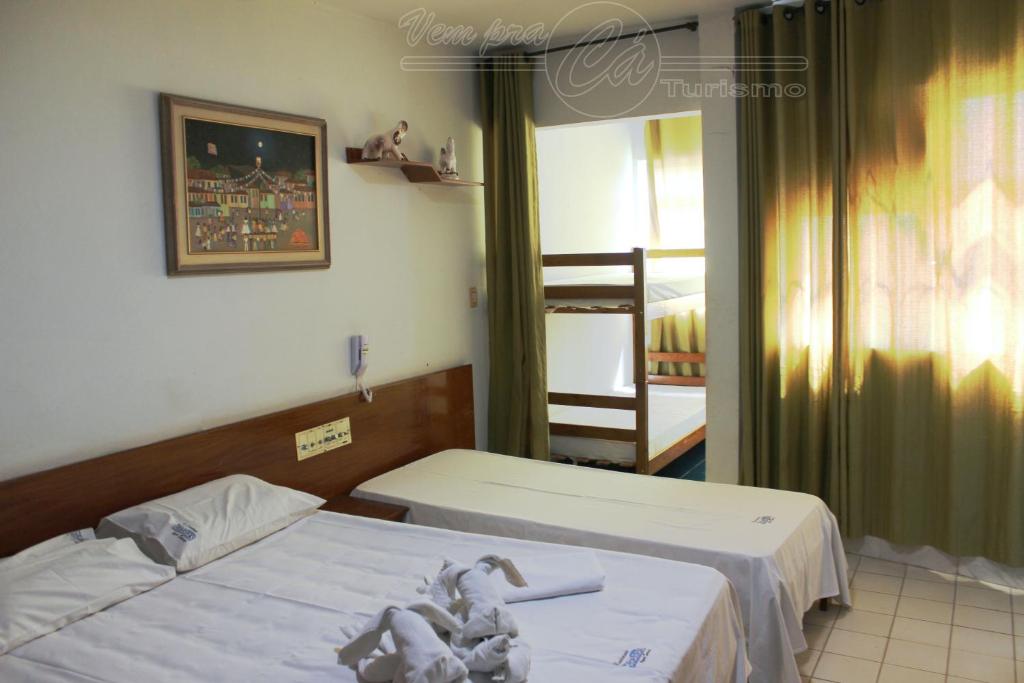 two twin beds in a room with a window at Condomínio CTC Araras, Caldas Novas - VPC in Caldas Novas