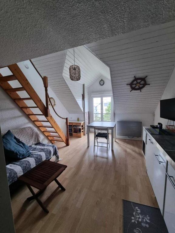 un salon avec une table et un escalier dans l'établissement Résidence Port du Crouesty - maeva Home - Appartement 2 pièces 4 personnes - Confort MAE-3324, à Arzon