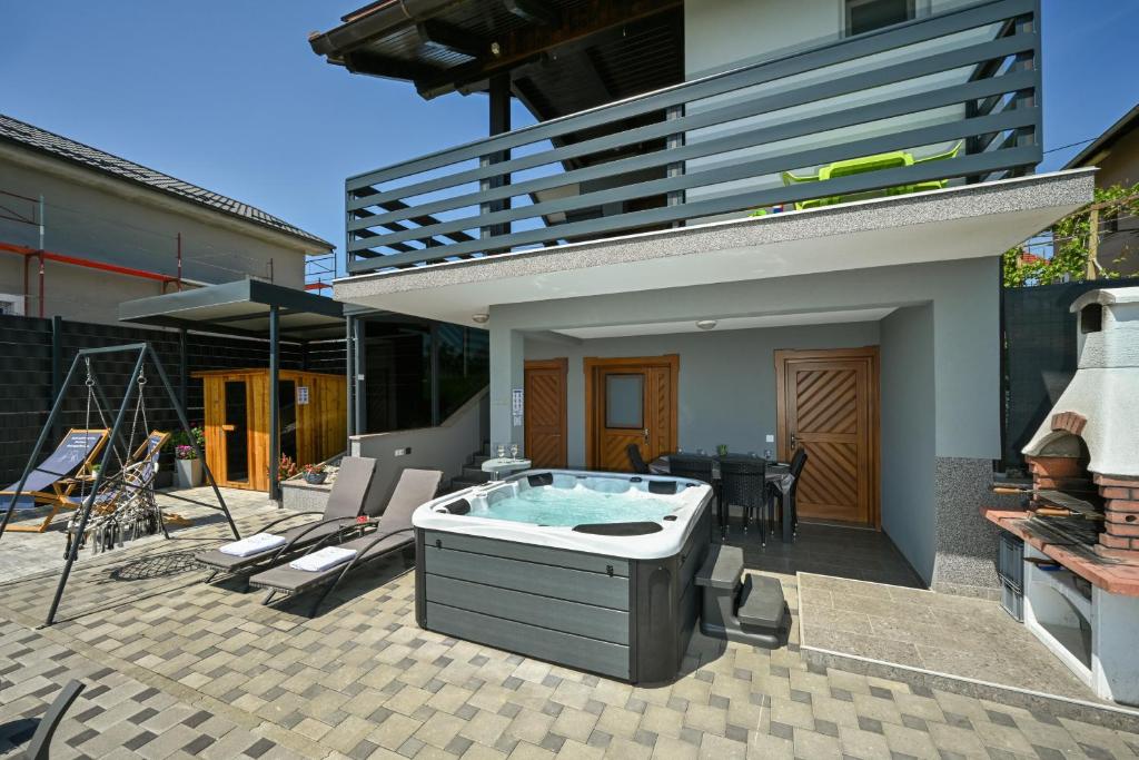 a hot tub in a patio with a house at View&Wine Jacuzzi -Tuheljske toplice in Veliko Trgovišće