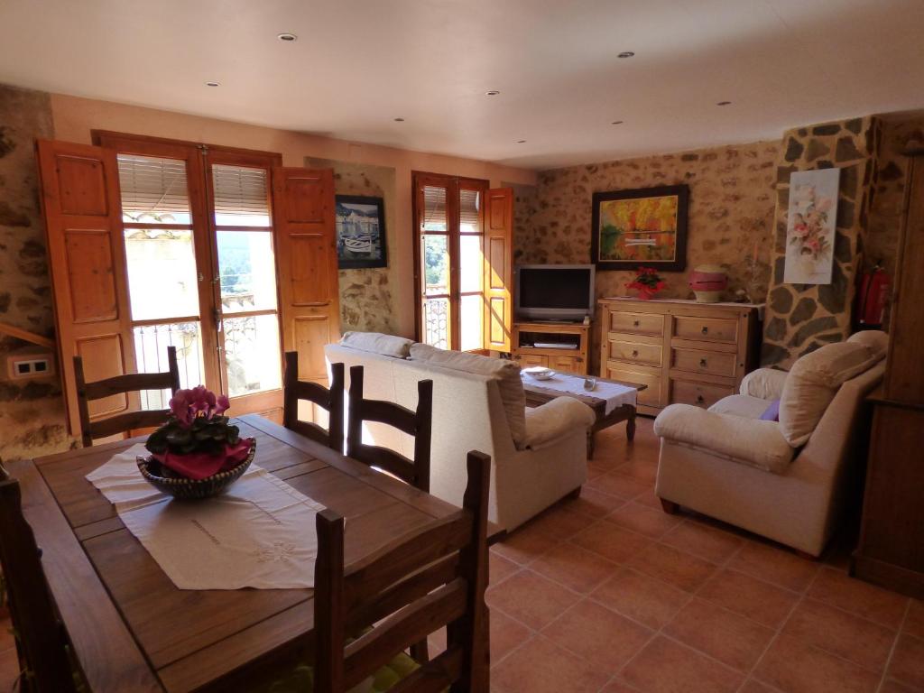 a living room with a wooden table and chairs at La serreta de Paüls in Paúls