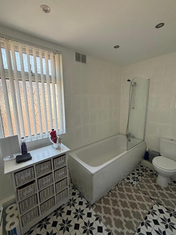 a white bathroom with a tub and a toilet at Single bedroom 1 in Anfield in Liverpool