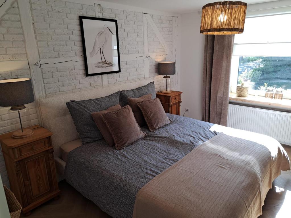 a bedroom with a bed with two lamps and a window at Ferienwohnung auf dem Mühlenhof in Glinstedt