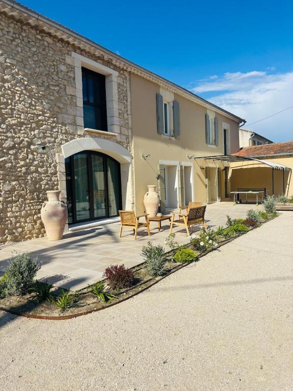 un patio avec deux chaises et un bâtiment dans l'établissement Le Mas de Sandre, en campagne, à Châteaurenard
