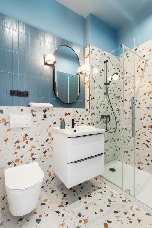 Hotel Apartament Zorza, a bathroom with a toilet sink and a shower at Apartament Zorza in Toruń