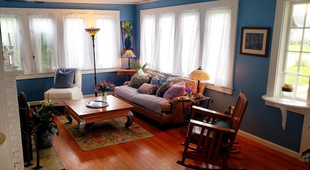 een woonkamer met een bank en een tafel bij Enchanted Cottage 1 block to beach in Madison