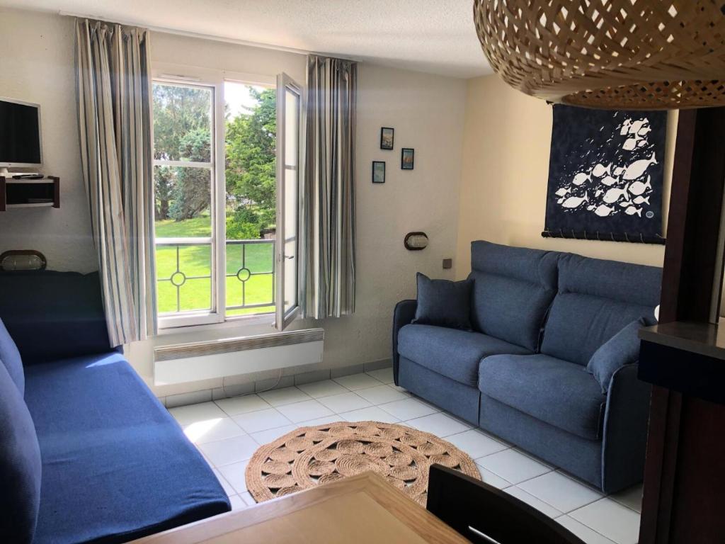 - un salon avec des canapés bleus et une fenêtre dans l'établissement Résidence Port du Crouesty - maeva Home - Appartement 2 Pièces 4 Personnes - Confort MAE-6444, à Arzon
