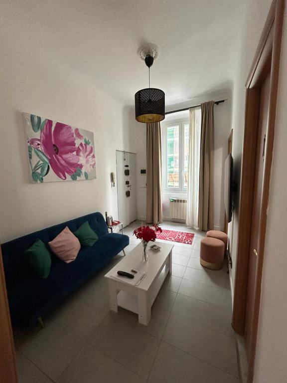 uma sala de estar com um sofá azul e uma mesa em Appartamento confortevole em Génova